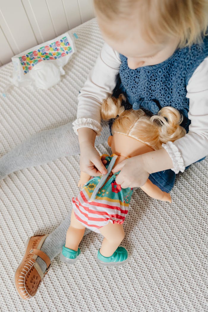 Mastering the First Impression: Your intriguing post title goes here A young girl on a bed engagingly plays with a doll, showcasing a peaceful and playful moment.